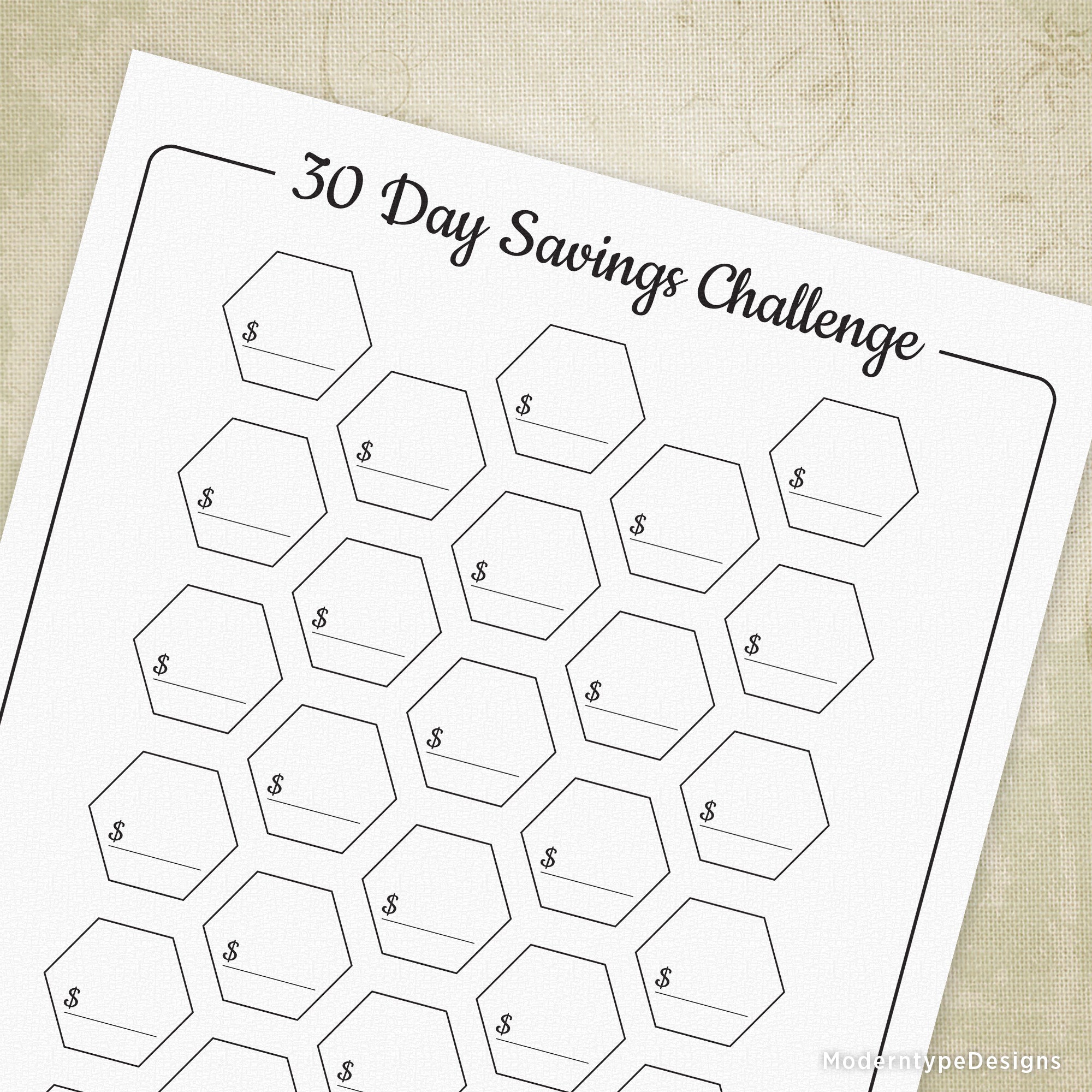 A printable 30 Day Savings Challenge PDF with a white background and a grid of boxes with '30 Day Savings Challenge' text, and spaces for writing in daily amounts.