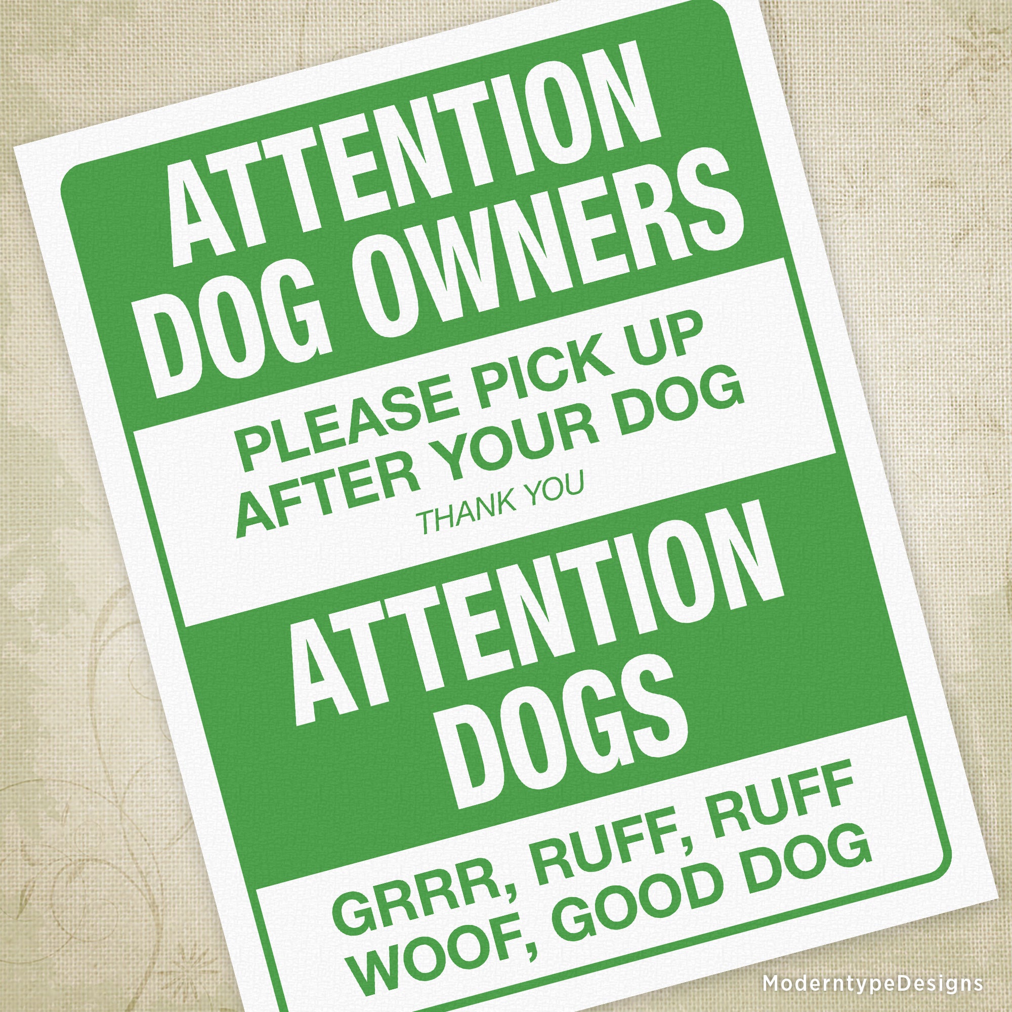 A green and white printable sign with the text 'Attention Dogs Owners PLEASE PICK UP AFTER YOUR DOG THANK YOU' and a paw print symbol.