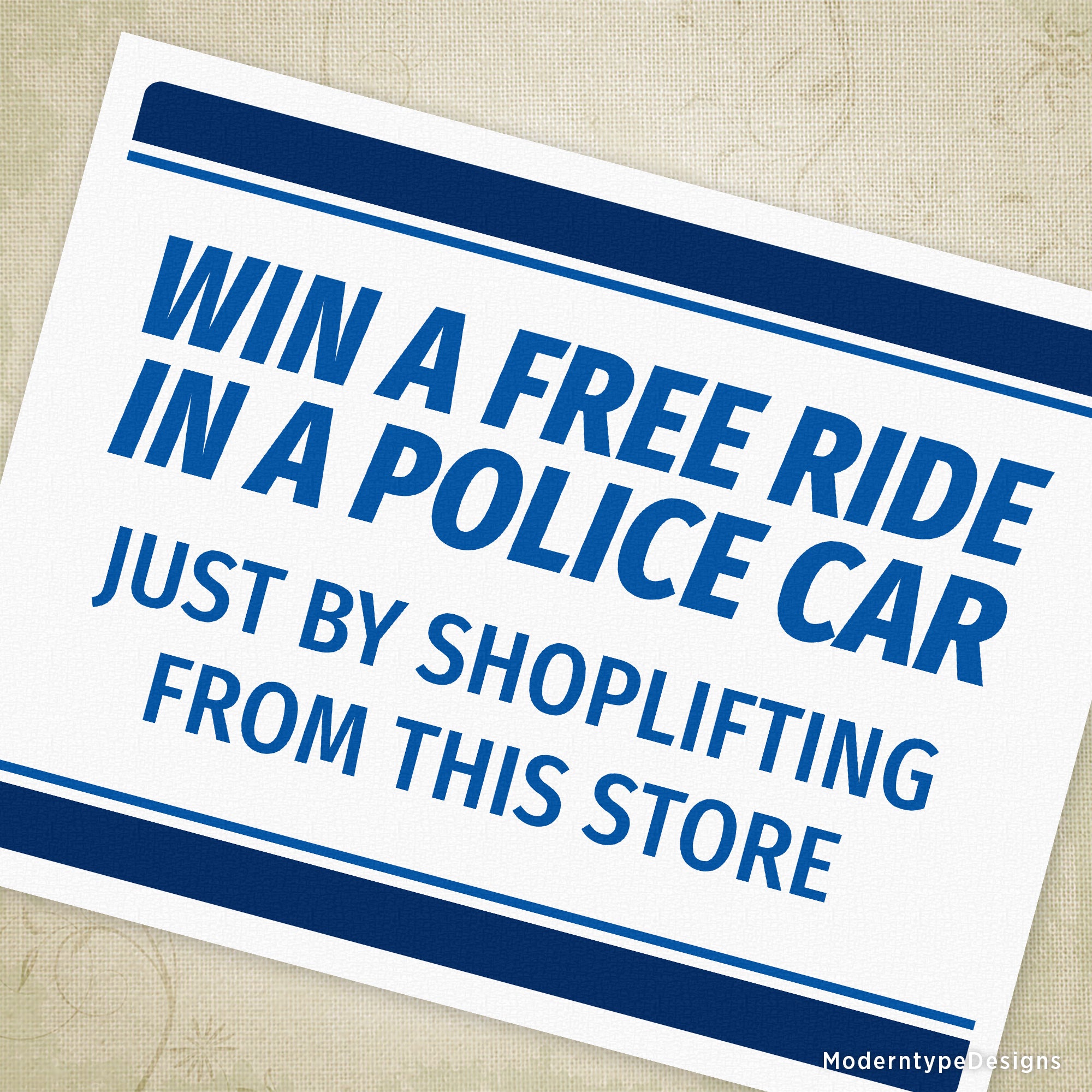 A sign with a blue background and white text that reads 'WIN A FREE RIDE IN A POLICE CAR JUST BY SHOPLIFTING FROM THIS STORE' with a blue borderline.
