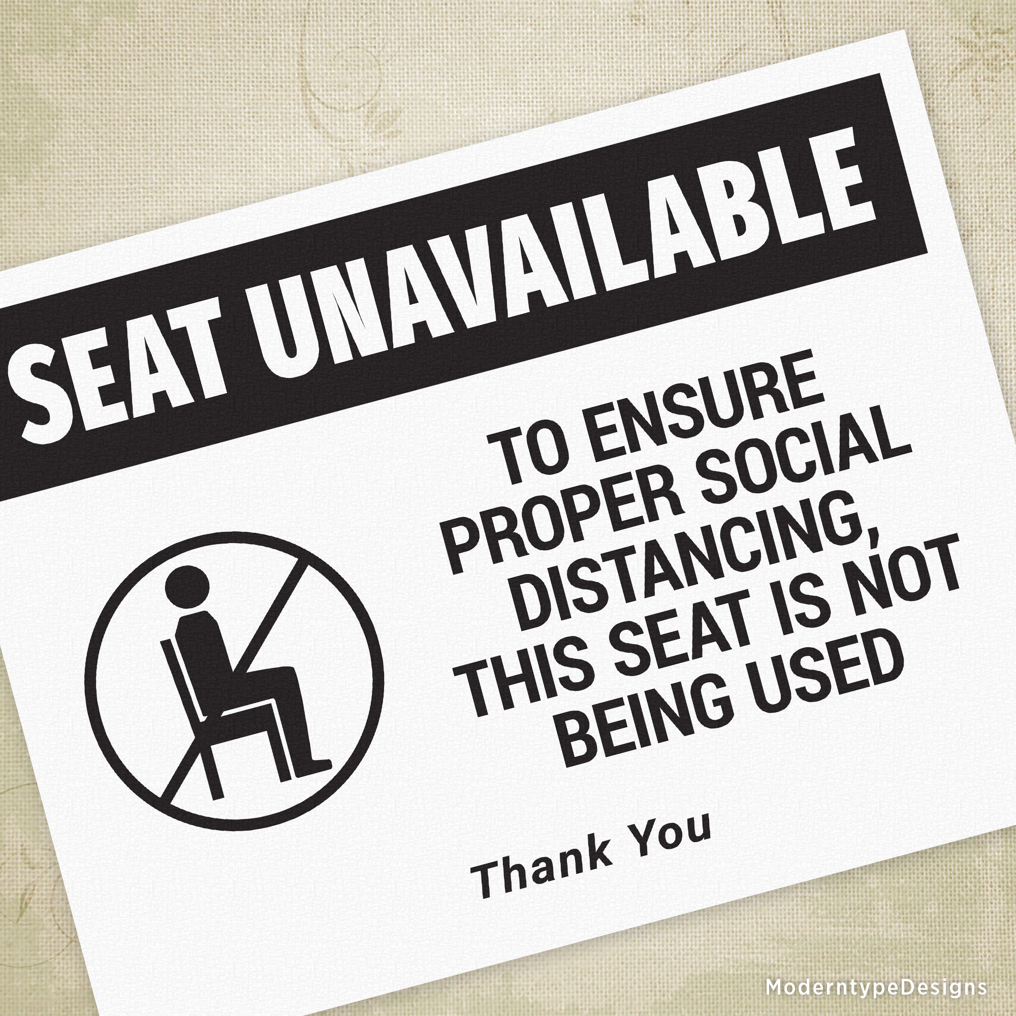 A printable sign with a black and white design indicating a seat that is unavailable, with a graphic of a person sitting and text stating 'To ensure social proper distancing, this seat is not being used.'.